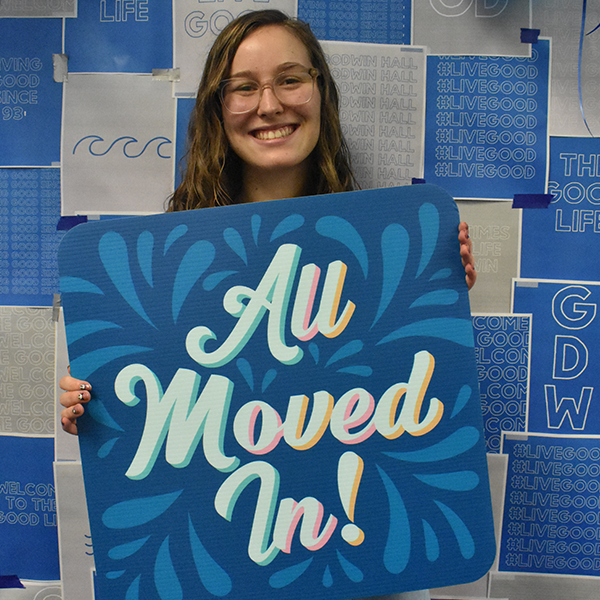 NSU Florida student smiling and holding a sign that says "All Moved In"